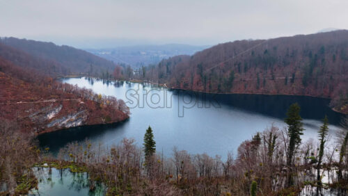 Video – Aerial drone view of fog covered turquoise lakes separated by narrow forested islands at Plitvice Lakes, Croatia - Starpik Stock