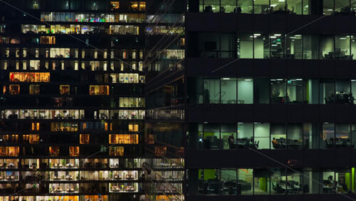 Video – Aerial drone view of illuminated office windows inside a modern skyscraper in central Warsaw - Starpik Stock