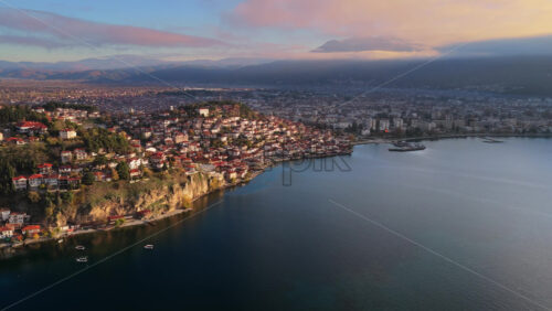 Video – Aerial drone view of the Old Town of Ohrid, North Macedonia peninsula, its red roofed houses, and the modern part of Ohrid stretching along the lakeshore - Starpik Stock