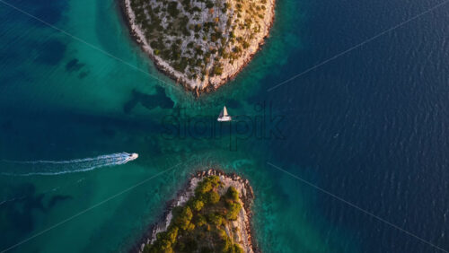Video – Aerial drone view of the Tribunj archipelago showing vibrant turquoise water flowing between rocky Adriatic islands. Croatia - Starpik Stock