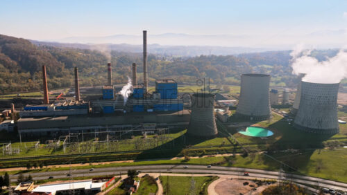 Video – Aerial drone view of the Tuzla power plant complex with multiple chimneys, cooling towers, and electrical infrastructure - Starpik Stock
