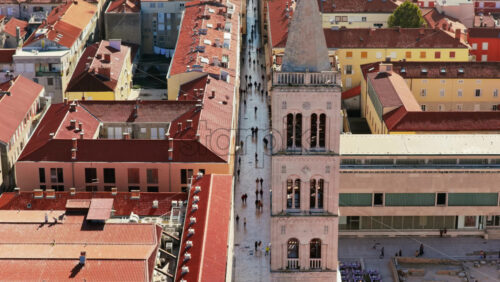 Video – Aerial drone view of the bell tower of St. Anastasia’s Cathedral and Zadar’s famous marble street, Kalelarga, lined with traditional Mediterranean buildings and red tiled roofs - Starpik Stock