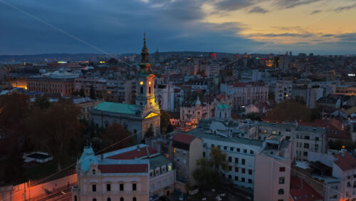 Video – Aerial drone view of the historic center of Belgrade at sunset, featuring the illuminated Cathedral of St. Michael and the traditional architecture of Old Belgrade - Starpik Stock