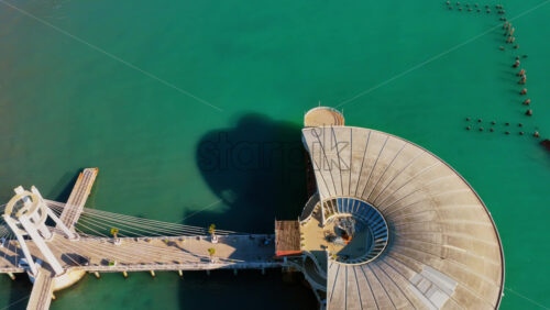 Video – Aerial drone view of the iconic circular Rotonda building extending over the turquoise waters of the Adriatic Sea in Durres, Albania - Starpik Stock