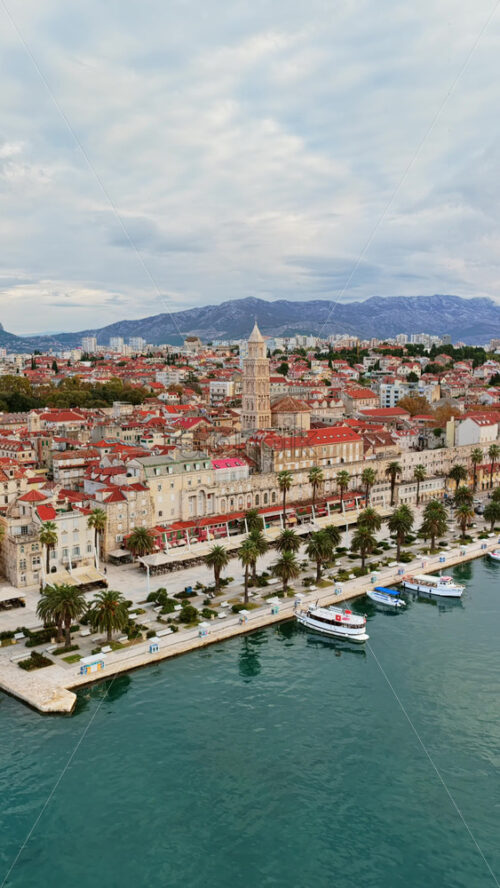 Video – Aerial drone view of the tall bell tower of St. Anastasia Cathedral rising above Zadar’s red roofed historic center. Vertical - Starpik Stock