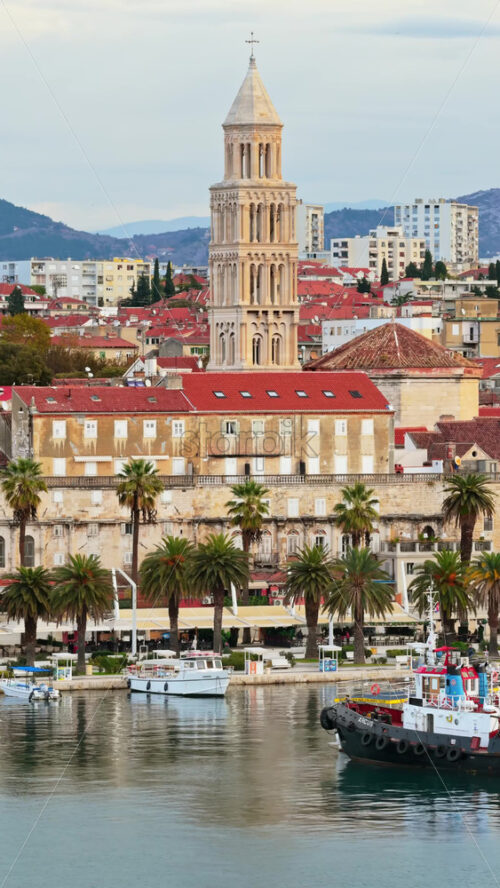 Video – Aerial drone view of the tall bell tower of St. Anastasia Cathedral rising above Zadar’s red roofed historic center. Vertical - Starpik Stock