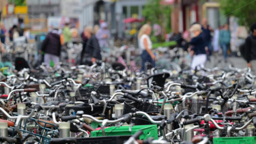 Video – Copenhagen, Denmark – August 4, 2025: Parking area filled with many bicycles as people walk past in a busy city - Starpik Stock