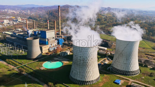 Video - Aerial drone view of several large cooling towers releasing steam into the air at the Tuzla Power Plant