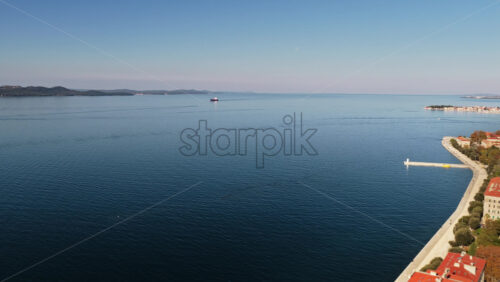 Video - Aerial drone view of Zadar's red roofed buildings along the bright blue Adriatic Sea