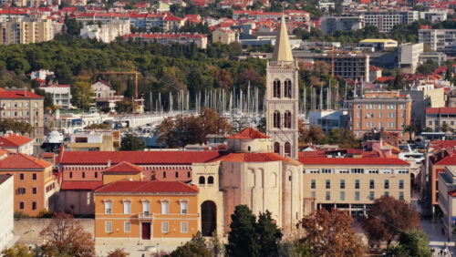 Video - Aerial drone view of Zadar's waterfront and historic Old Town, with St. Anastasia Cathedral's bell tower prominently visible