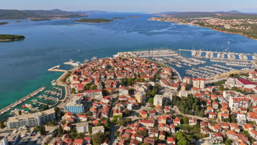 Video - Aerial drone view of Biograd na Moru's old town peninsula, surrounded by turquoise Adriatic waters and multiple marinas filled with yachts. Croatia