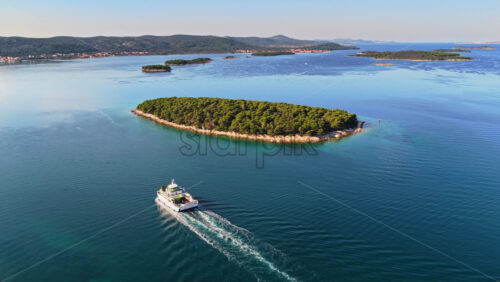 Video - Aerial drone view of a ferry traveling through the Pasman Channel, surrounded by small, lush green islands