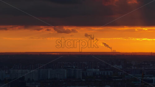 Video - Aerial drone view of Belgrade with the silhouette of a distant industrial plant and smokestack emitting clouds of steam