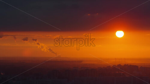Video - Aerial drone view of a large telecommunications tower set against an intense orange sunset over Belgrade, Serbi