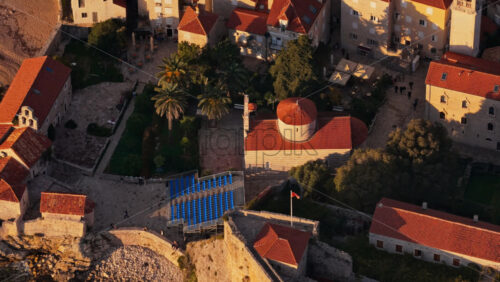 Video - Aerial drone view of the warm toned stone rooftops and narrow streets of Budva's Old Town. Montenegro
