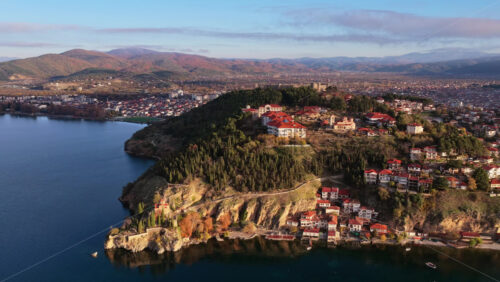 Video - Aerial drone view of Samuil's Fortress, the Plaosnik archaeological complex, and Ohrid's hilltop neighborhoods surrounded by mountains. North Macedonia