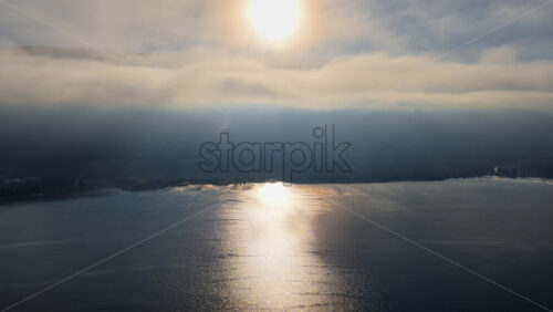 Video - Aerial drone view of a Galichica mountain ridge rising above a sea of clouds, with soft layers of fog covering the valley below