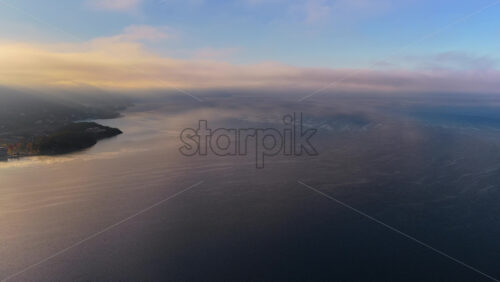Video - Aerial drone view of a Galichica mountain ridge rising above a sea of clouds, with soft layers of fog covering the valley below