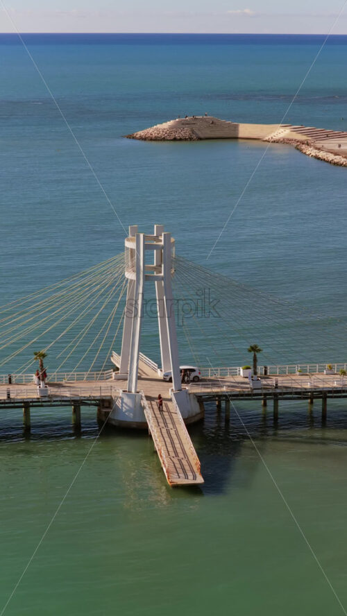 Video - Aerial drone view of the iconic circular Rotonda building extending over the turquoise waters of the Adriatic Sea in Durres, Albania. Vertical