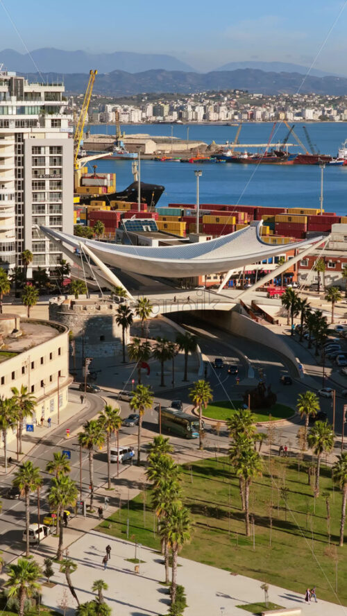 Video - Aerial drone view of the futuristic white, sail shaped pedestrian and vehicular overpass near the port in Durres, Albania. Vertical