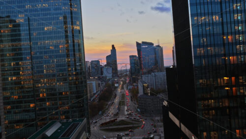 Video - Warsaw, Poland - October 30, 2025: Aerial drone view between skyscrapers toward Rondo ONZ at dusk