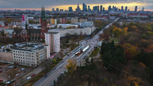 Video - Warsaw, Poland - October 31, 2025: Aerial drone view of St. Florian's Cathedral in the Praga district, with autumn trees and the modern Warsaw skyline in the background