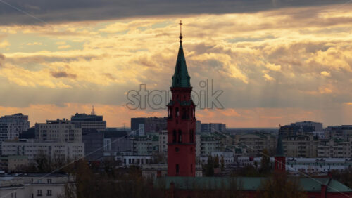 Video - Warsaw, Poland - October 31, 2025: Aerial drone view of the tower of St. James Apostol Church in Ochota, Warsaw, set against dramatic cloud formations during early evening light