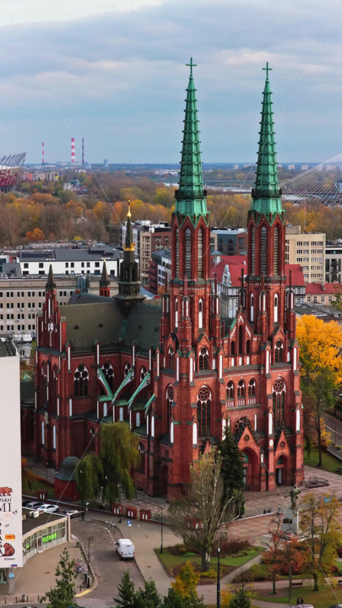 Video - Warsaw, Poland - October 31, 2025: Aerial drone view of the facade of St. Florian Cathedral in Praga, featuring its brickwork and symmetrical Gothic design. Vertical