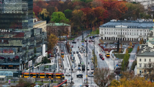 Video - Warsaw, Poland - October 31, 2025: Aerial drone view of traffic, trams, and pedestrians moving through a major intersection near Plac Bankowy and Rondo ONZ