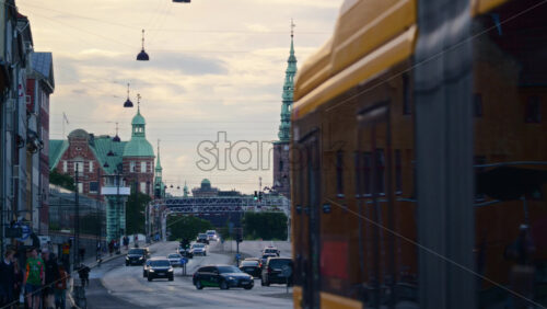 Video - Copenhagen, Denmark - August 2, 2025: City street with a bus, cars, and Nikolaj Kunsthal tower at dusk