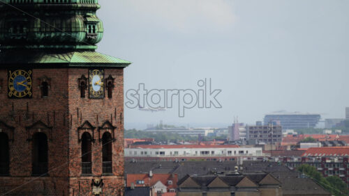 Video - Church clock tower made of brick and copper overlooking city roofs and buildings. Copenhagen, Denmark