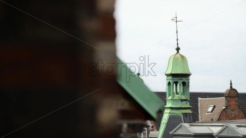 Video - Weathered green copper cupola and weather vane topping a historic building spire. Copenhagen, Denmark