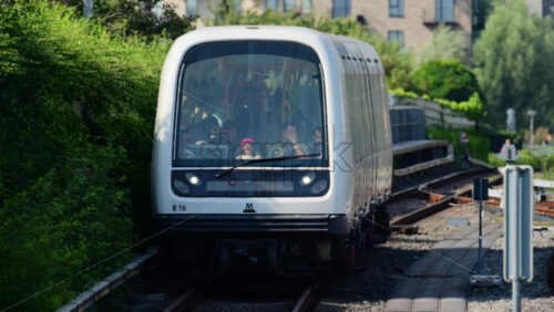 Video - Copenhagen, Denmark - August 4, 2025: Driverless metro train carrying passengers arriving at a city station in summer