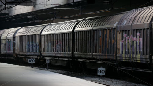 Video - Copenhagen, Denmark - August 5, 2025: Freight train wagons with graffiti standing on tracks at a railway station