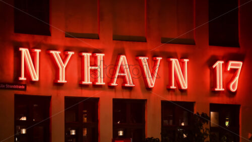 Video - Copenhagen, Denmark - August 5, 2025: Nyhavn 17 restaurant building featuring a striking red neon sign in Copenhagen, Denmark at night