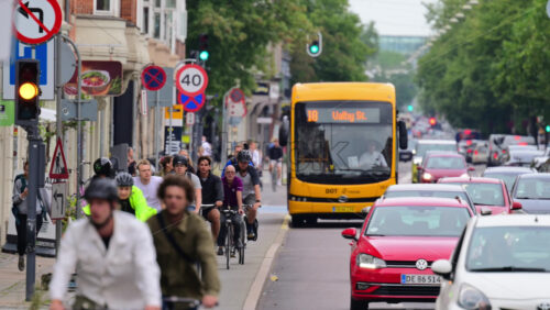 Video - Copenhagen, Denmark - August 5, 2025: Commuters cycling and driving on a busy city street during the day
