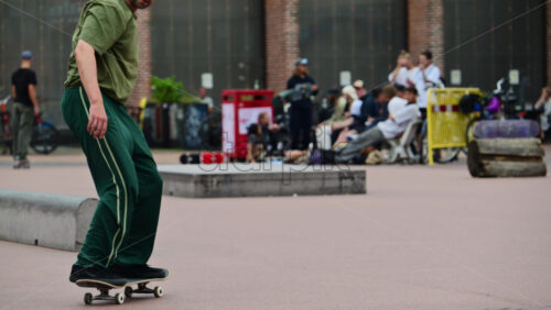 Video - Copenhagen, Denmark - August 5, 2025: Man skateboarding in a city square, performing a trick in slow motion in Red Square