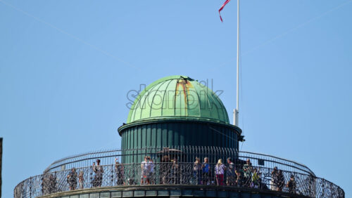 Video - Copenhagen, Denmark - August 6, 2025: Rundetarn's historic observatory dome and viewing platform with people and Denmark's flag