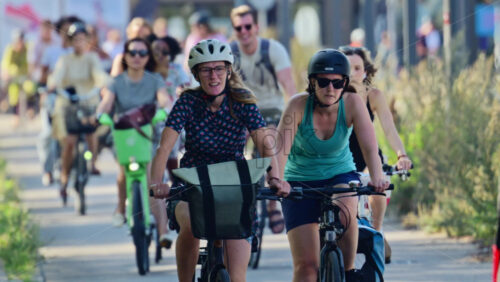 Video - Copenhagen, Denmark - August 6, 2025: Crowd of diverse people riding bicycles along a cycling path in a city park