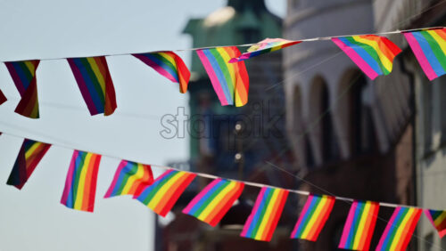 Video - Rainbow flags strung overhead celebrating community and inclusion during an event. Copenhagen, Denmark