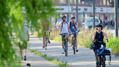 Video - Copenhagen, Denmark - August 6, 2025: People riding bicycles on a dedicated bike path surrounded by residential buildings
