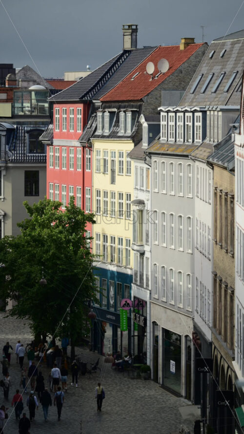 Video - Copenhagen, Denmark - August 6, 2025: People enjoying a stroll on a charming pedestrian street lined with colorful buildings