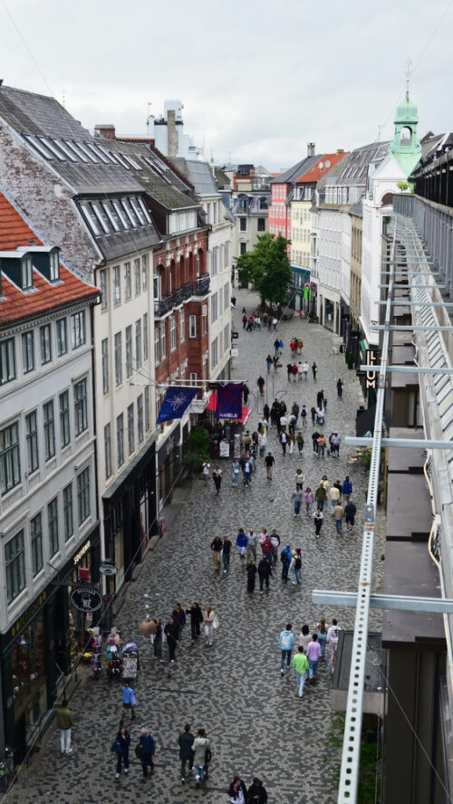 Video - Copenhagen, Denmark - August 6, 2025: Crowds of shoppers and tourists enjoying the vibrant cobblestone street in Denmark