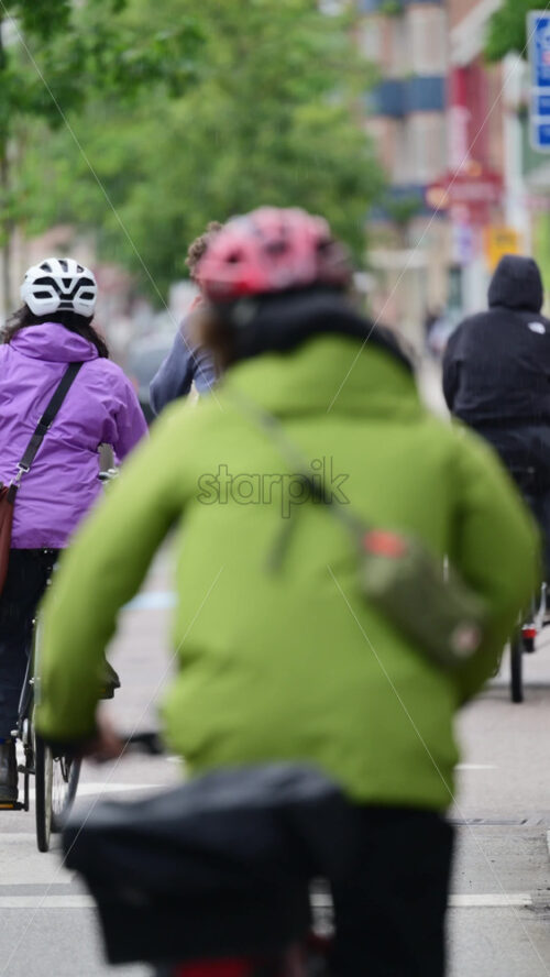 Video - Copenhagen, Denmark - August 7, 2025: Group of cyclists riding bikes in a city, one man signaling with a peace sign
