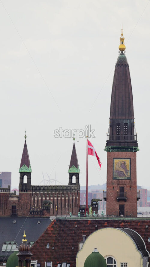 Video - Copenhagen, Denmark - August 7, 2025: City Hall tower flying a Danish flag, with surrounding rooftops and city architecture