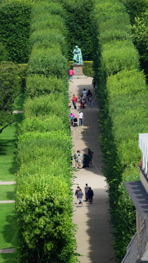 Video - Copenhagen, Denmark - August 7, 2025: Tourists walking past the Hans Christian Andersen statue in the green King's Garden