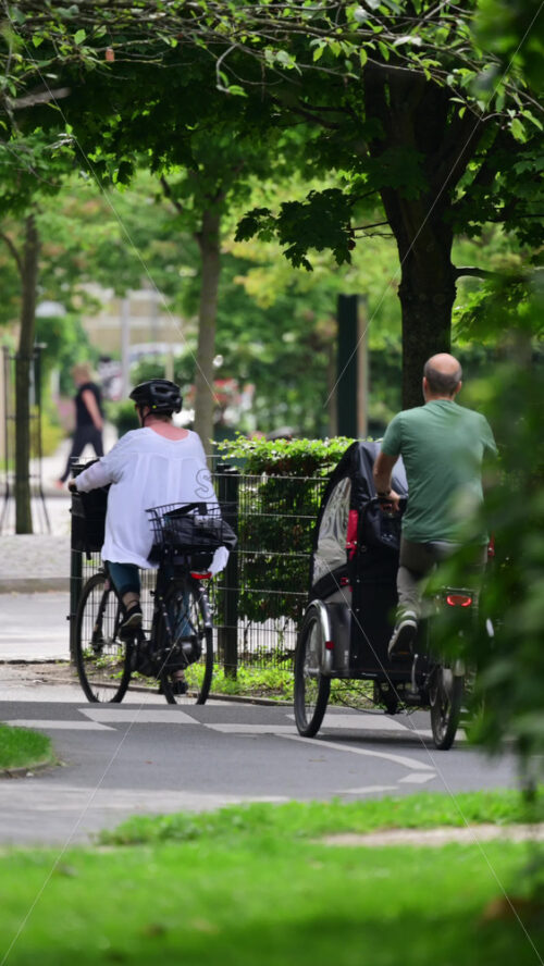 Video - Urban park landscape featuring green foliage and bicyclists riding in Copenhagen, Denmark