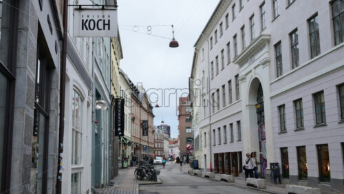 Video - Copenhagen, Denmark - August 3, 2025: Copenhagen street scene featuring traditional buildings, shops, and pedestrians under an overcast sky