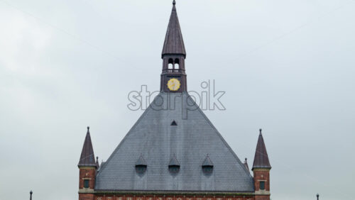 Video - Historic red brick railway station building in Copenhagen city center with modern digital clock. Denmark