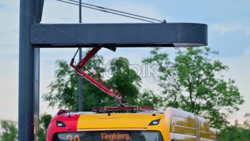 Video - Copenhagen, Denmark - August 2, 2025: Electric bus receiving power from an overhead pantograph charging station in a city